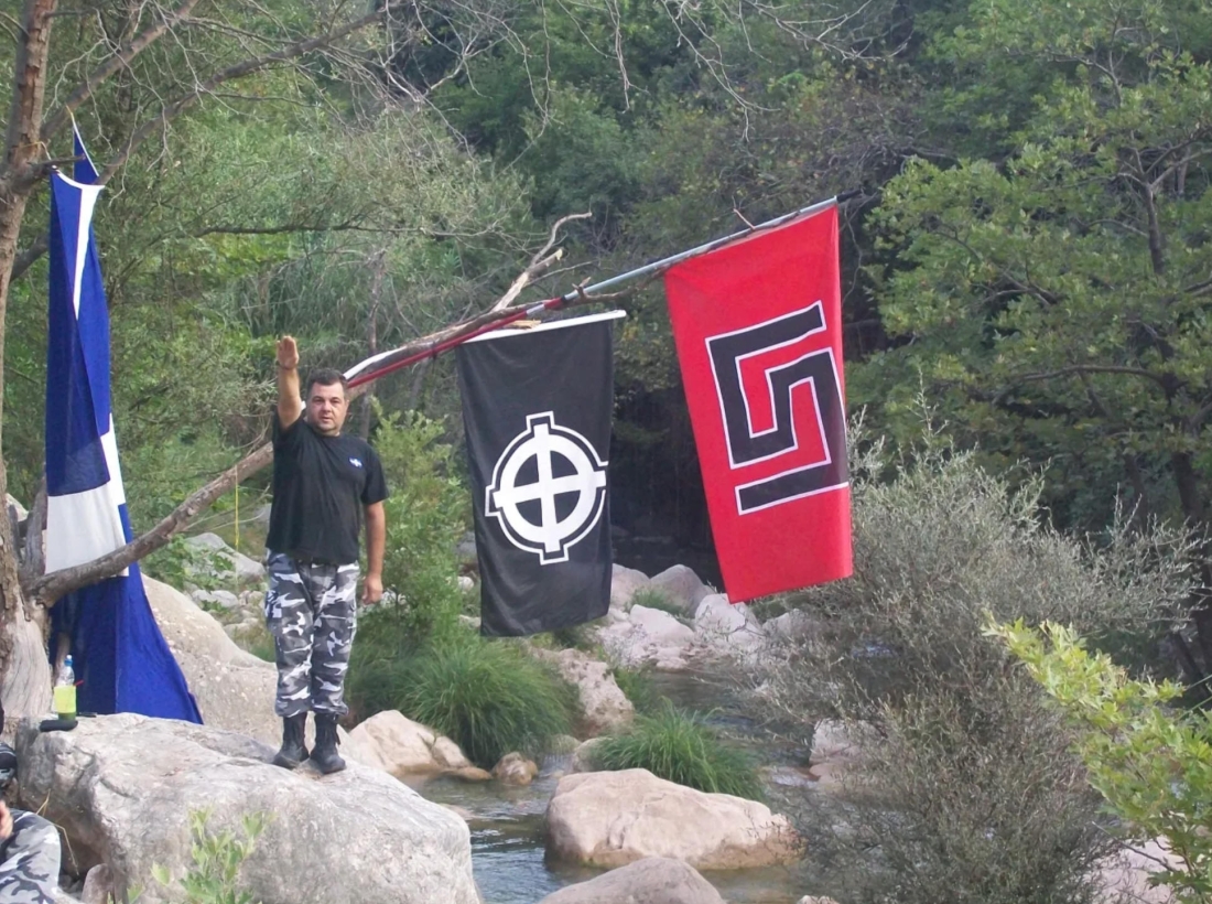 O δολοφόνος του Παύλου Φύσσα, Γεώργιος Ρουπακιάς, στη διάρκεια εκπαίδευσης, υπό τις σημαίες με τα σύμβολα της Χρυσής Αυγής. Φωτογραφία από τη δικογραφία.